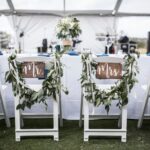 Wedding table under tent, with Mr and Mrs signs on the chairs
