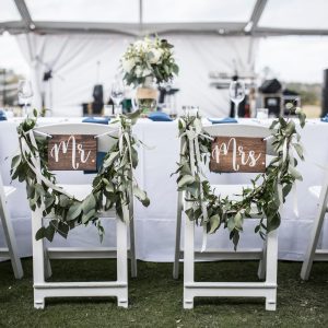 Wedding table under tent, with Mr and Mrs signs on the chairs